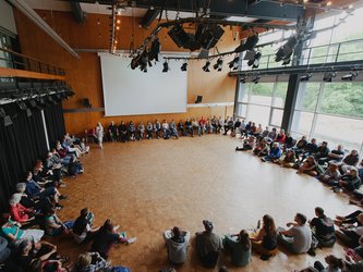 viele Menschen sitzen im Kreis