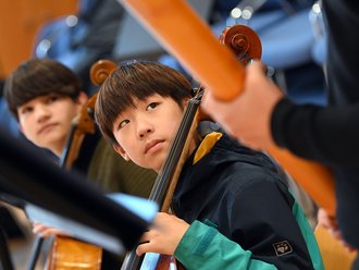 Jungen spielen ein Streichinstrument