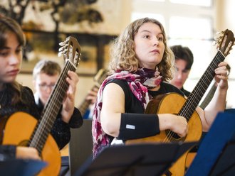 blonde Frau spielt Gitarre
