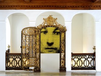 geöffnete goldene Gittertür vor Wandgemälde