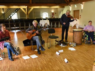 4 Menschen üben (eine Gitarre, eine Geige)