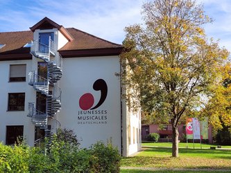 weißes Haus mit Aufschrift "Jeunesses Musicales Deutschland"